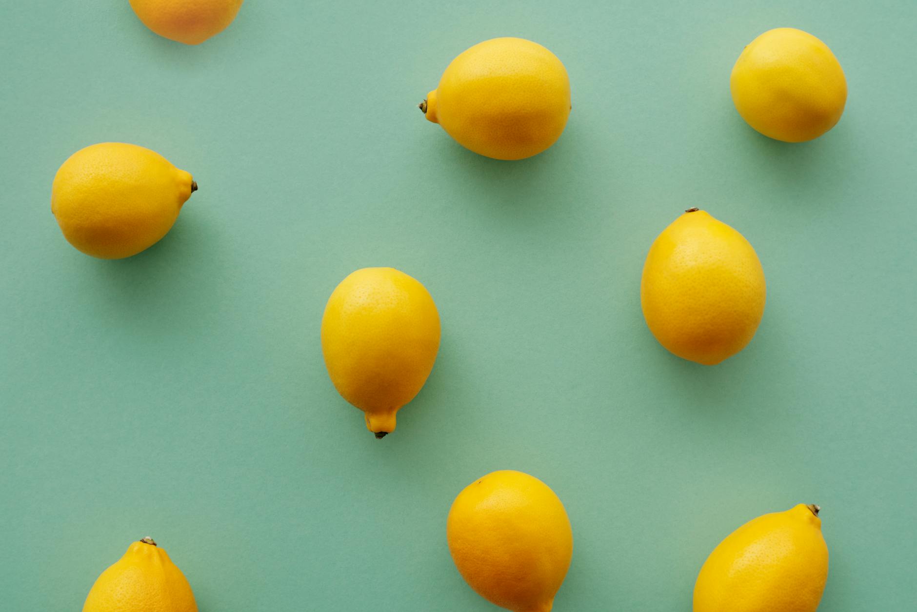 Bright yellow lemons arranged on a pastel green background, representing fresh approaches to pleasure with hormonal birth control