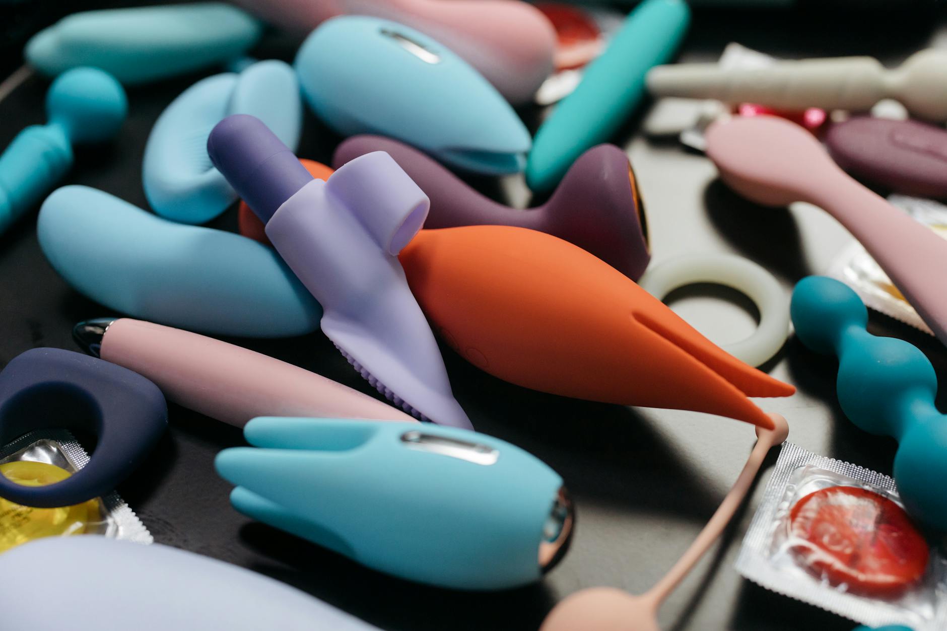 An array of vibrant clitoral vibrators and adult toys displayed in close-up detail