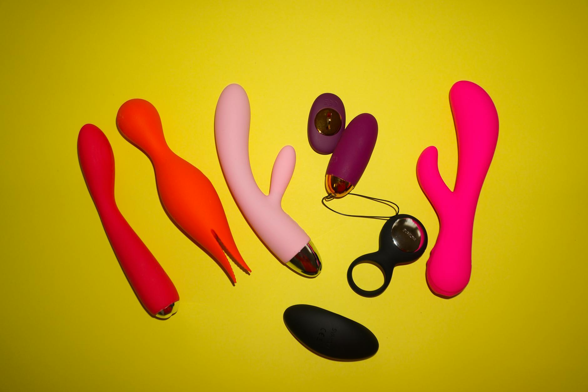 Colorful arrangement of various lemon and berry vibrators on a bright yellow surface