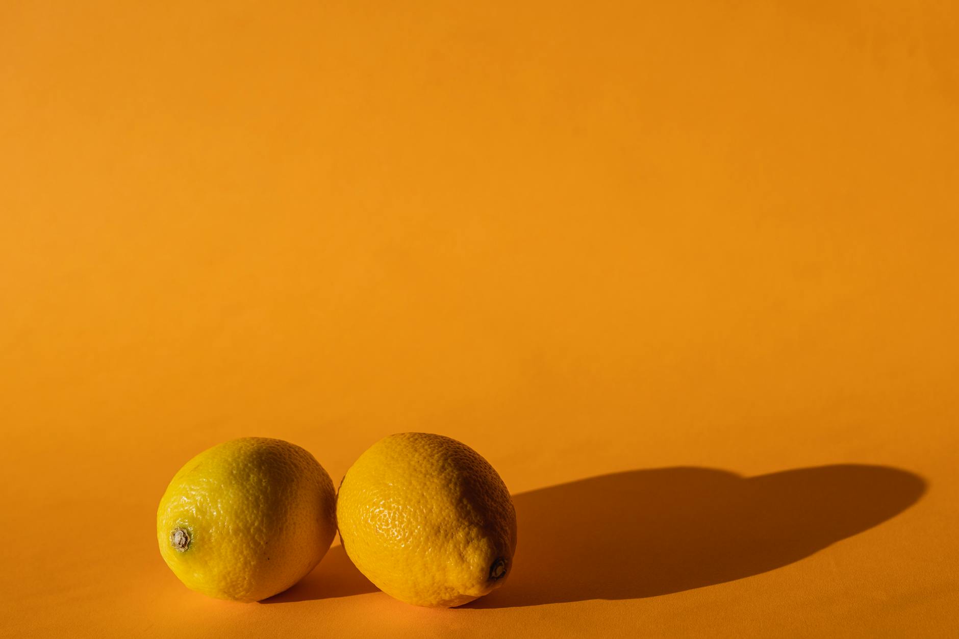 Ripe vivid lemons on a bright yellow background, symbolizing freshness and vitality